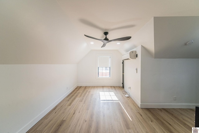 bonus room featuring a wall unit AC, light hardwood / wood-style flooring, ceiling fan, and vaulted ceiling