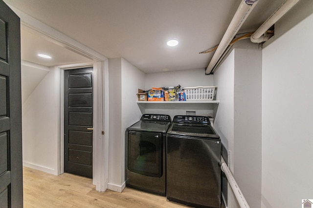 washroom with washer and dryer and light wood-type flooring