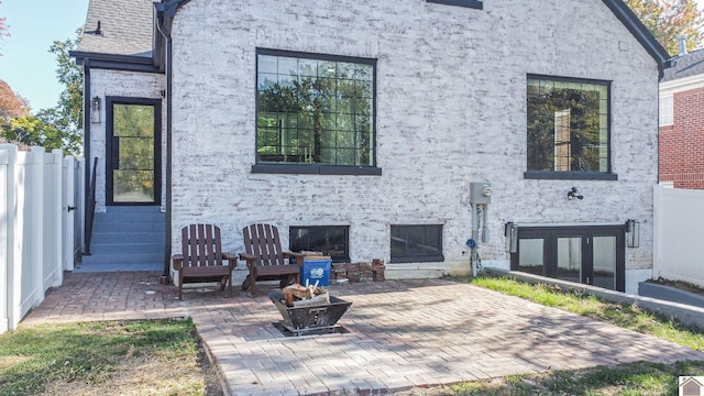 rear view of property with a patio and an outdoor fire pit