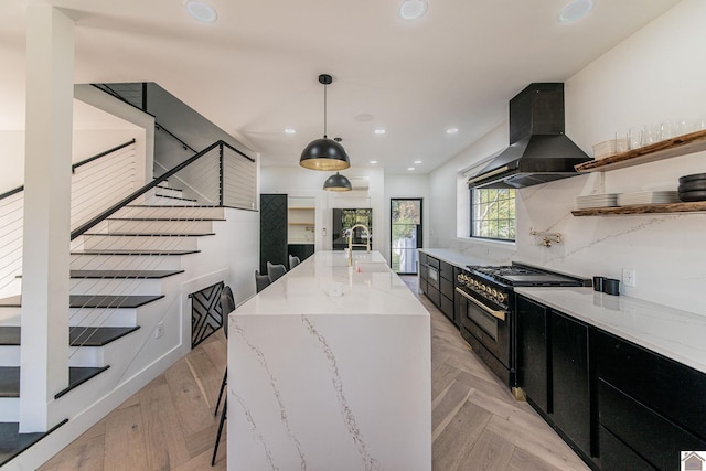 kitchen with exhaust hood, a large island, light stone countertops, pendant lighting, and double oven range