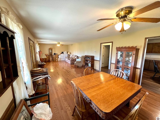 dining room with hardwood / wood-style floors, a textured ceiling, and ceiling fan