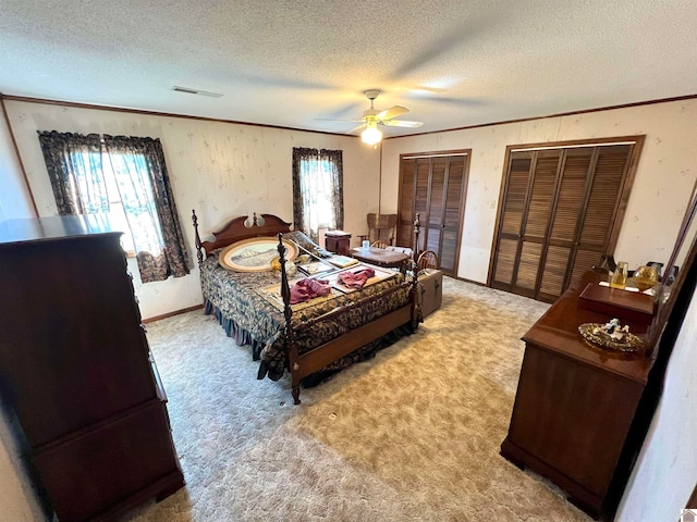 bedroom with multiple closets, a textured ceiling, carpet floors, and ceiling fan