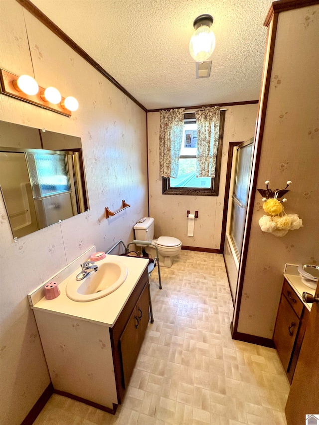 bathroom with vanity, toilet, a textured ceiling, and a shower with shower door