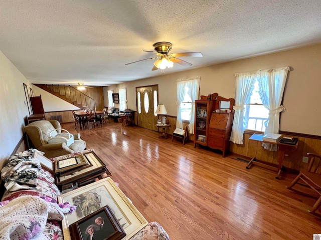 living room featuring a textured ceiling, hardwood / wood-style flooring, and wood walls