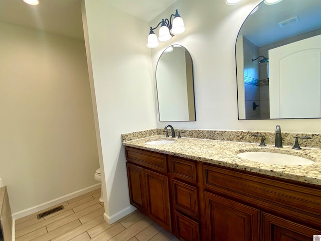 bathroom featuring toilet, hardwood / wood-style floors, vanity, and a shower