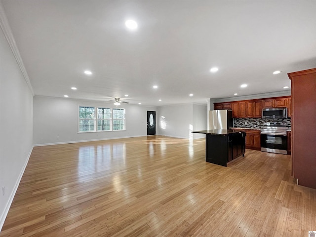 kitchen featuring tasteful backsplash, appliances with stainless steel finishes, ornamental molding, light hardwood / wood-style floors, and a center island