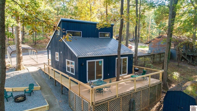 back of property featuring a deck and an outdoor fire pit