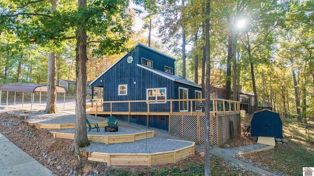 back of house with a wooden deck and a carport