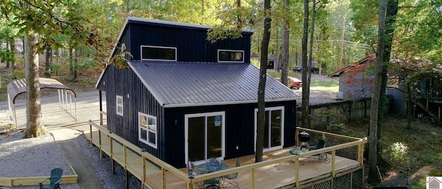 rear view of property featuring an outdoor structure, a deck, and a garage