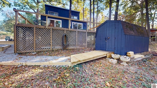 back of house featuring a storage unit and a deck