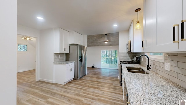 kitchen featuring white cabinets, a wealth of natural light, light hardwood / wood-style flooring, stainless steel appliances, and decorative light fixtures