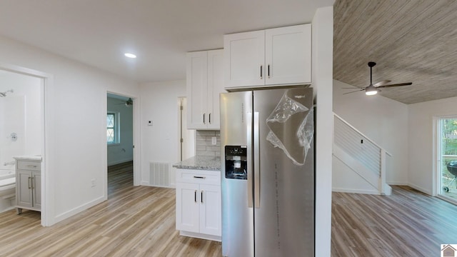 kitchen featuring decorative backsplash, light hardwood / wood-style flooring, stainless steel fridge with ice dispenser, white cabinets, and light stone counters