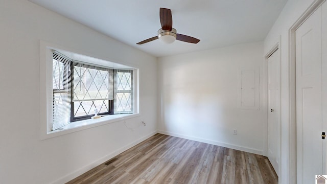 spare room featuring light hardwood / wood-style flooring and ceiling fan