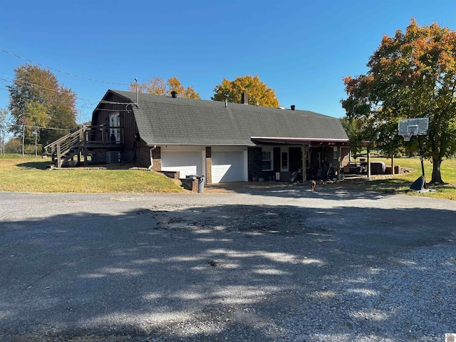 view of front of property featuring a carport, a front lawn, and a garage