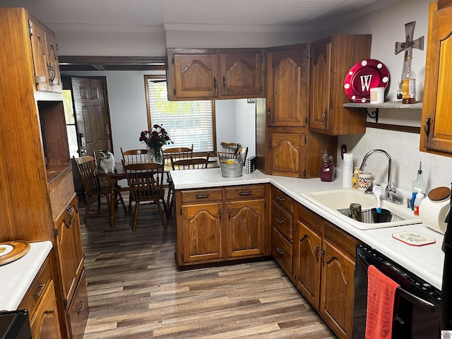 kitchen featuring dishwasher, sink, kitchen peninsula, hardwood / wood-style floors, and crown molding