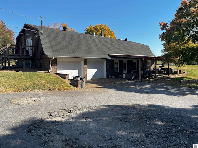 view of front of house with a front yard, central AC, and a garage