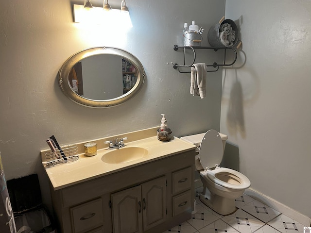 bathroom with toilet, vanity, and tile patterned floors