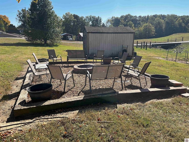 view of patio / terrace featuring a rural view, a fire pit, and an outdoor structure