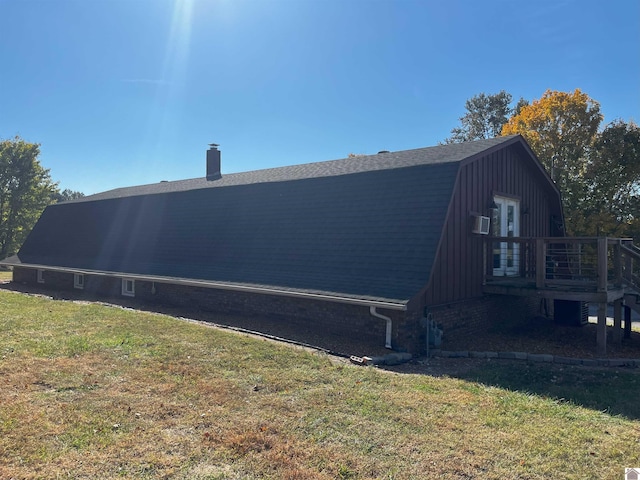 view of side of property with a wooden deck and a lawn