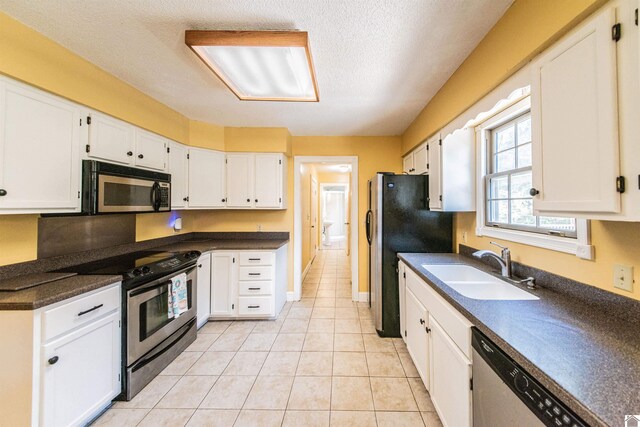9618 Scale Rd, Benton, KY 42025 - kitchen featuring dark countertops, appliances with stainless steel finishes, white cabinetry, and a sink