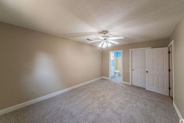 9618 Scale Rd, Benton, KY 42025 - unfurnished bedroom with light carpet, a textured ceiling, visible vents, baseboards, and connected bathroom