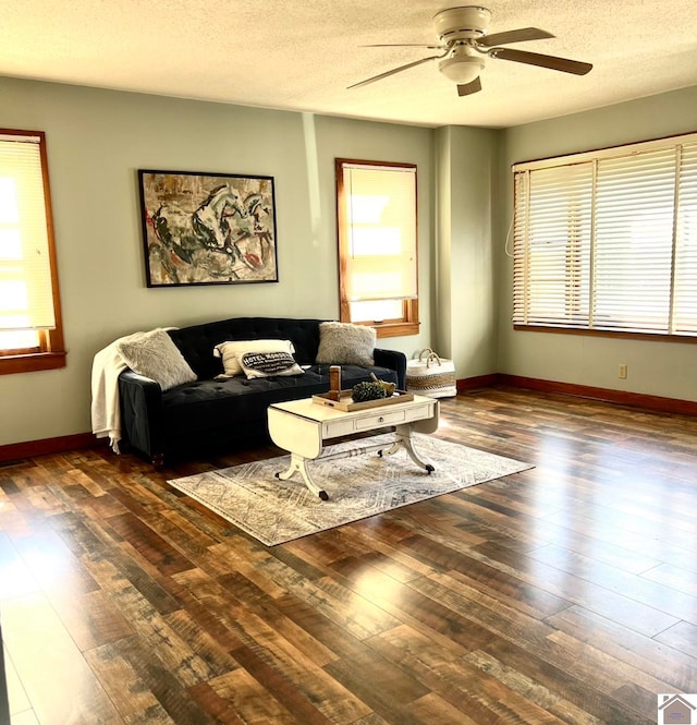 living room with ceiling fan, a textured ceiling, and dark hardwood / wood-style floors