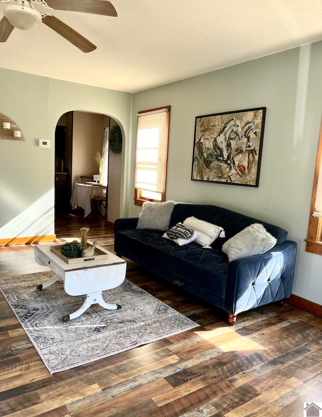 living room featuring ceiling fan and dark hardwood / wood-style floors