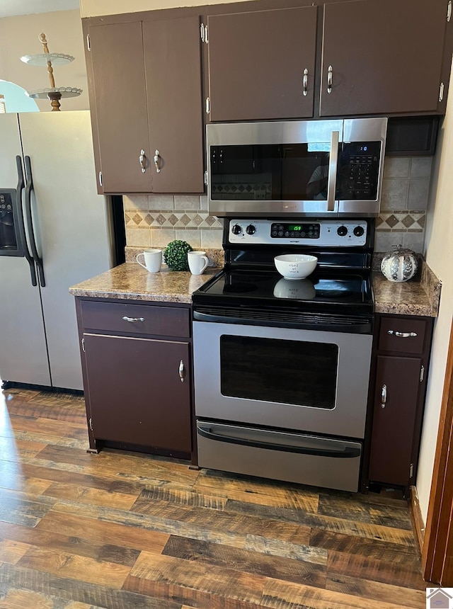 kitchen with appliances with stainless steel finishes, decorative backsplash, dark brown cabinetry, and dark wood-type flooring