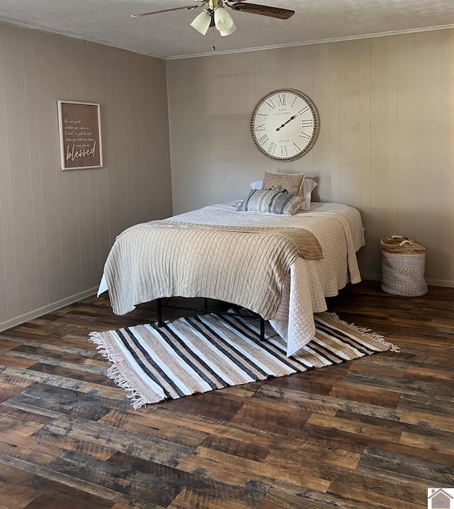 bedroom with wooden walls, dark hardwood / wood-style floors, and ceiling fan