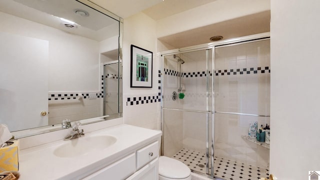 bathroom with vanity, toilet, and a shower with door