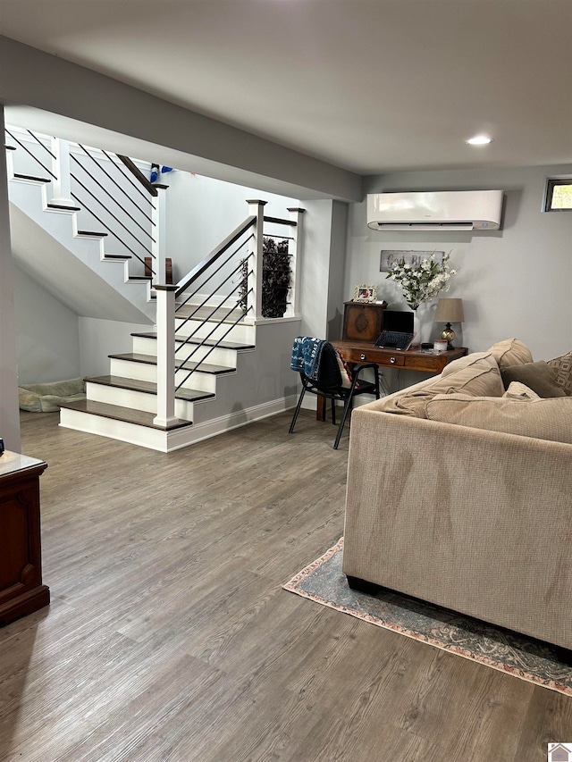 living room featuring hardwood / wood-style flooring and an AC wall unit