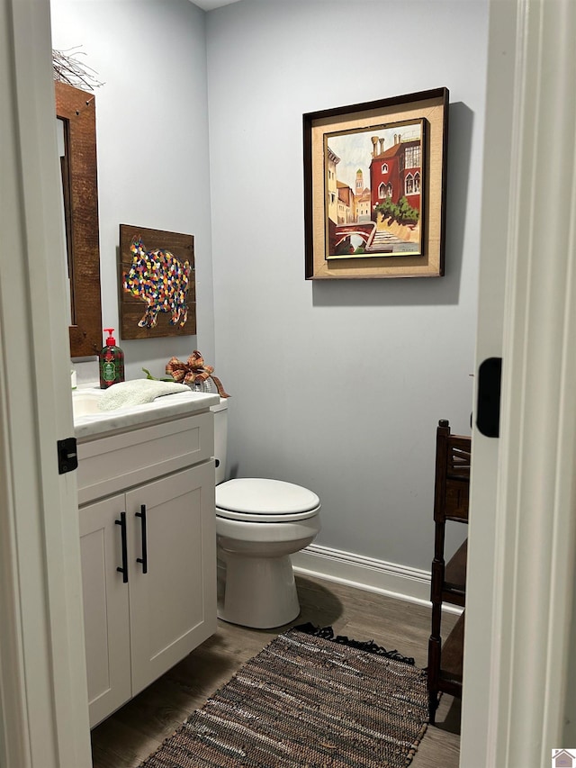 bathroom featuring toilet, hardwood / wood-style floors, and vanity