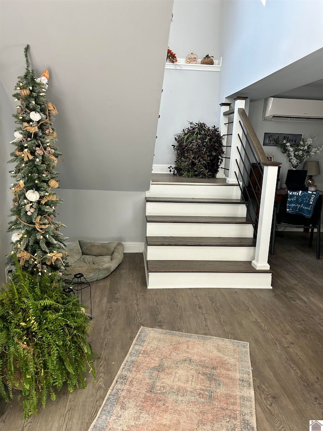 stairs with wood-type flooring and a wall mounted air conditioner