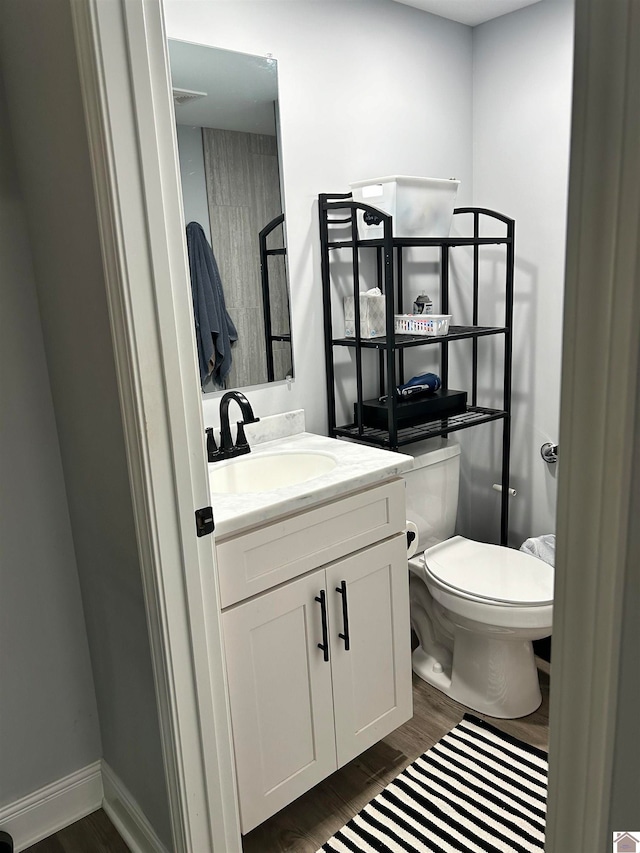 bathroom featuring vanity, toilet, and hardwood / wood-style floors