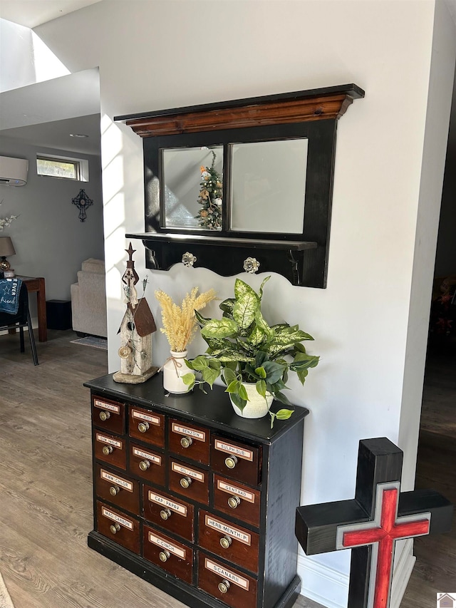 interior details featuring a wall unit AC and wood-type flooring