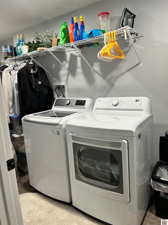 washroom with washer and clothes dryer and light carpet