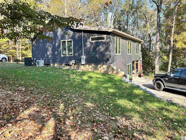 view of property exterior featuring central AC and a lawn