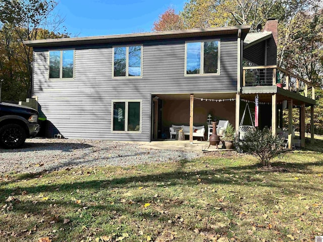 back of house with a patio and a lawn