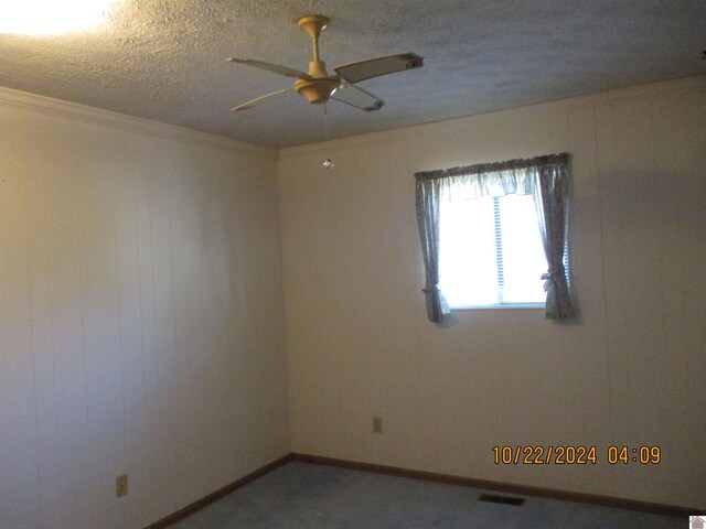 spare room featuring crown molding, a textured ceiling, and ceiling fan