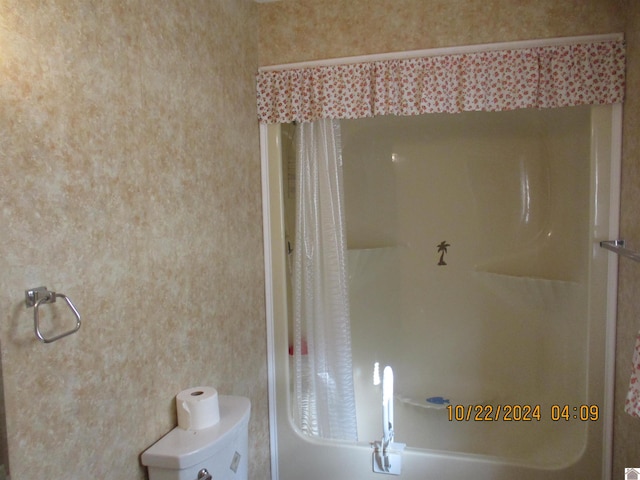 bathroom featuring toilet and shower / tub combo