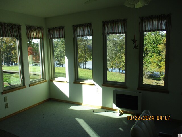 unfurnished sunroom with a wealth of natural light and a water view