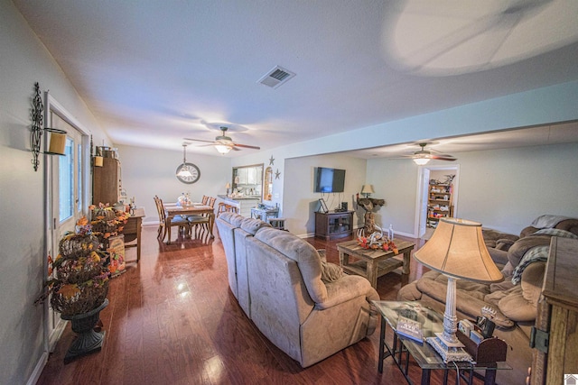 living room featuring ceiling fan and dark hardwood / wood-style flooring