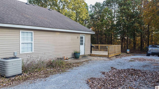 view of side of property with central air condition unit and a wooden deck