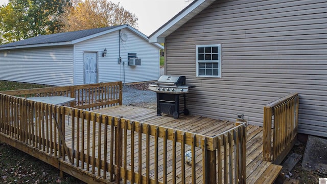 wooden terrace with area for grilling, a storage unit, and cooling unit