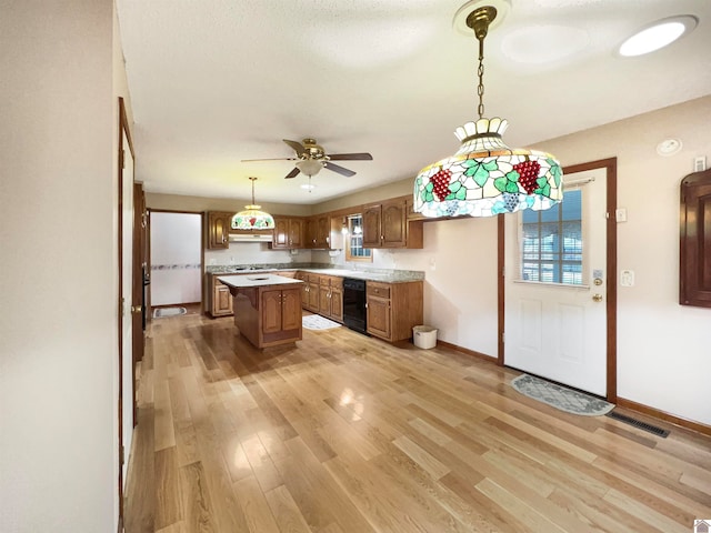 kitchen with pendant lighting, a center island, light wood-type flooring, and ceiling fan