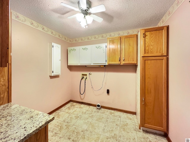 clothes washing area with cabinets, electric panel, ceiling fan, a textured ceiling, and hookup for a washing machine