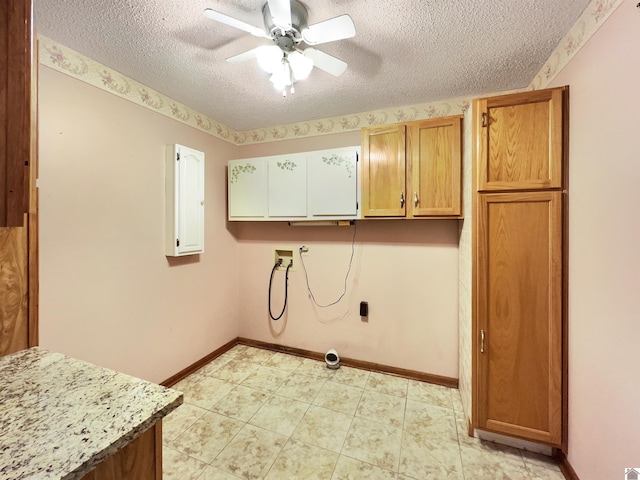 laundry area featuring ceiling fan, a textured ceiling, cabinet space, baseboards, and hookup for a washing machine