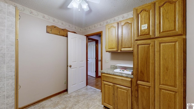 kitchen featuring ceiling fan and a textured ceiling