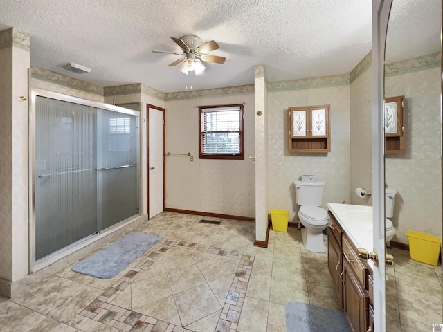 full bathroom featuring toilet, baseboards, a textured ceiling, a shower stall, and a ceiling fan