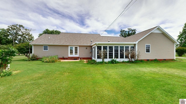 rear view of house with a lawn, french doors, and roof with shingles